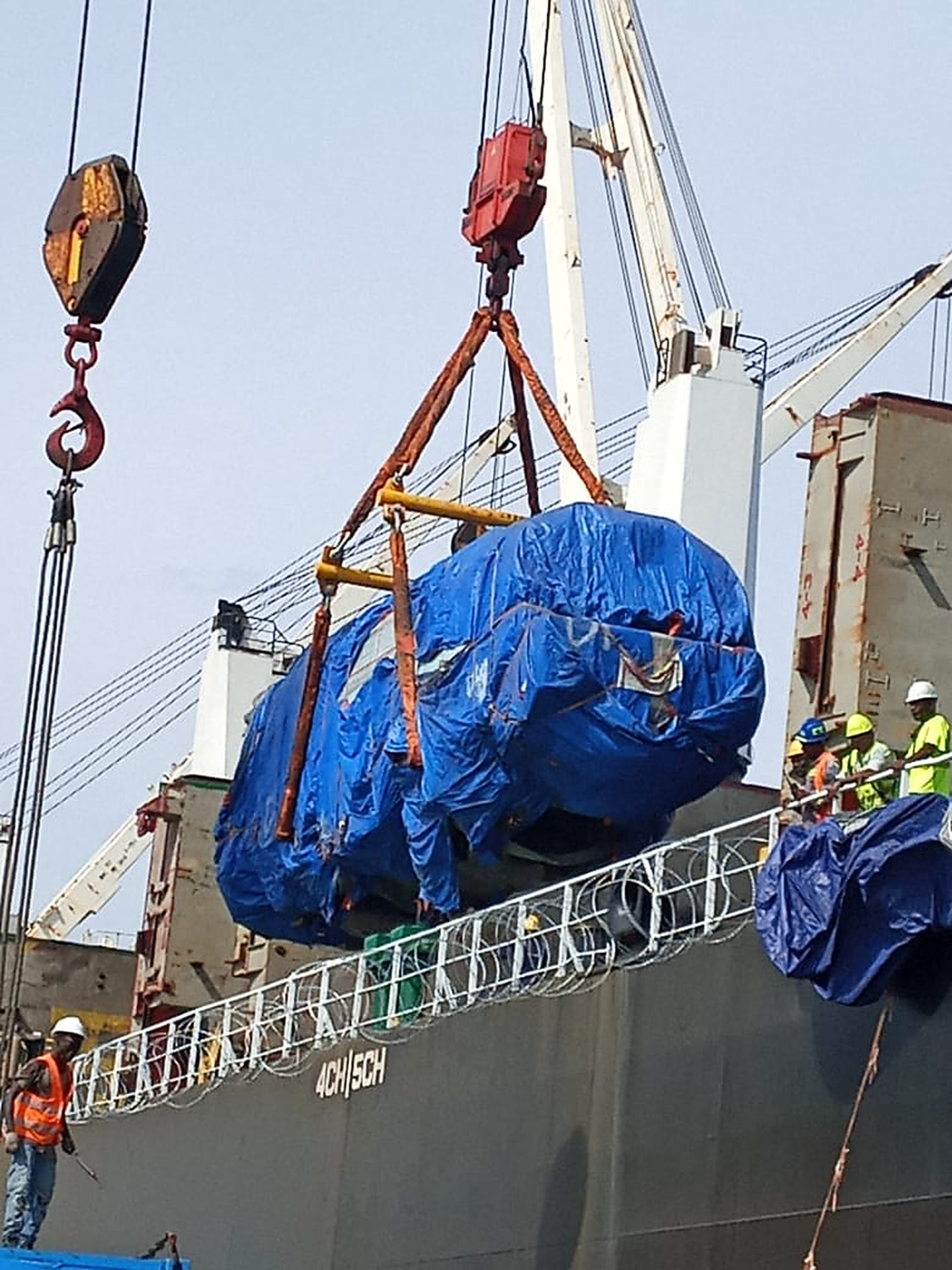 AND stevedores supervising a heavy-lift cargo discharge from a vessel